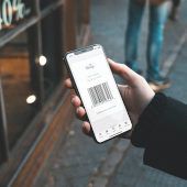 Person steht vor Laden mit geöffneter Kunden-App