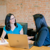 Eine Recruiterin bespricht mit einer Kandidatin verschiedene Jobangebote am Computer