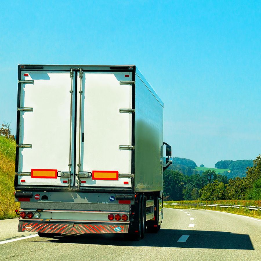Ein Lastwagen fährt auf einer Straße und ist auf dem Weg zur nächsten Lieferung.