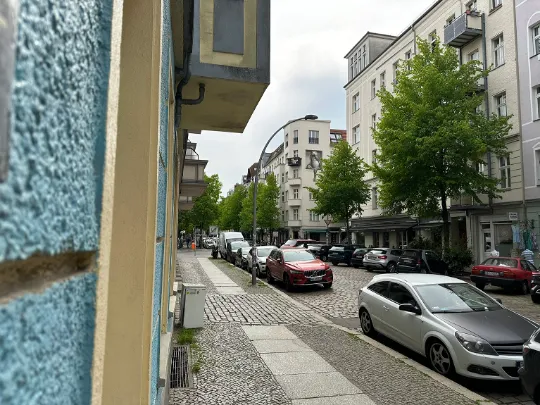 Eine Straße in der Wohngegend Friedrichshain. Bäume am Straßenrand sorgen für eine angenehme Atmosphäre. Die Wohnungen sind überwiegend saniert. 