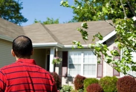 Hausbesitzer die von draußen auf ihr Eigentum schauen