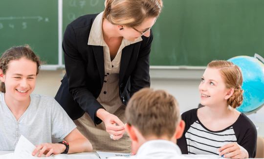 Lehrkraft im Lernforum gibt Schülern der Mittelstufe Nachhilfe nach dem individuellen Förderkonzept in der Minigruppe
