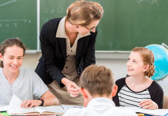 Lehrkraft im Lernforum gibt Schülern der Mittelstufe Nachhilfe nach dem individuellen Förderkonzept in der Minigruppe